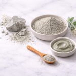 Bentonit kili tozu ve ham kil parçası — seramik kase ve ahşap kaşık