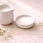 Keçi sütü (Caprae Lac) sabunu ve taze keçi sütü — seramik sürahi ve beyaz çiçekler