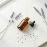 Lavanta yağı şişesi ve Lavandula angustifolia çiçekleri — mor lavanta