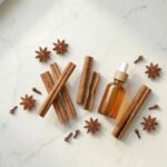 Tarçın kabuğu yağı ve Cinnamomum zeylanicum çubukları — baharatlı esansiyel yağ